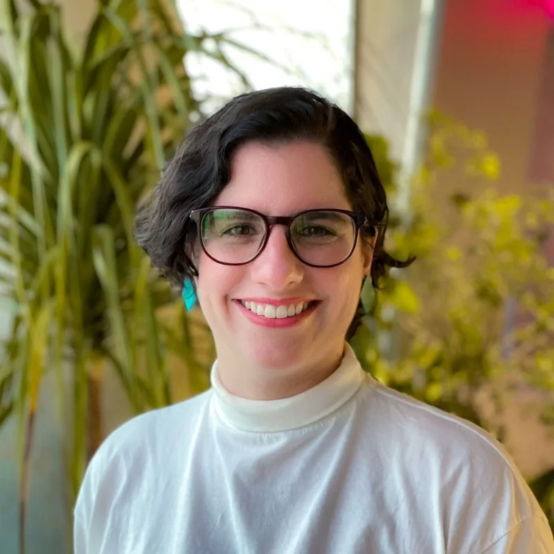 Mulher usando óculos e sorrindo - Alice Lucena